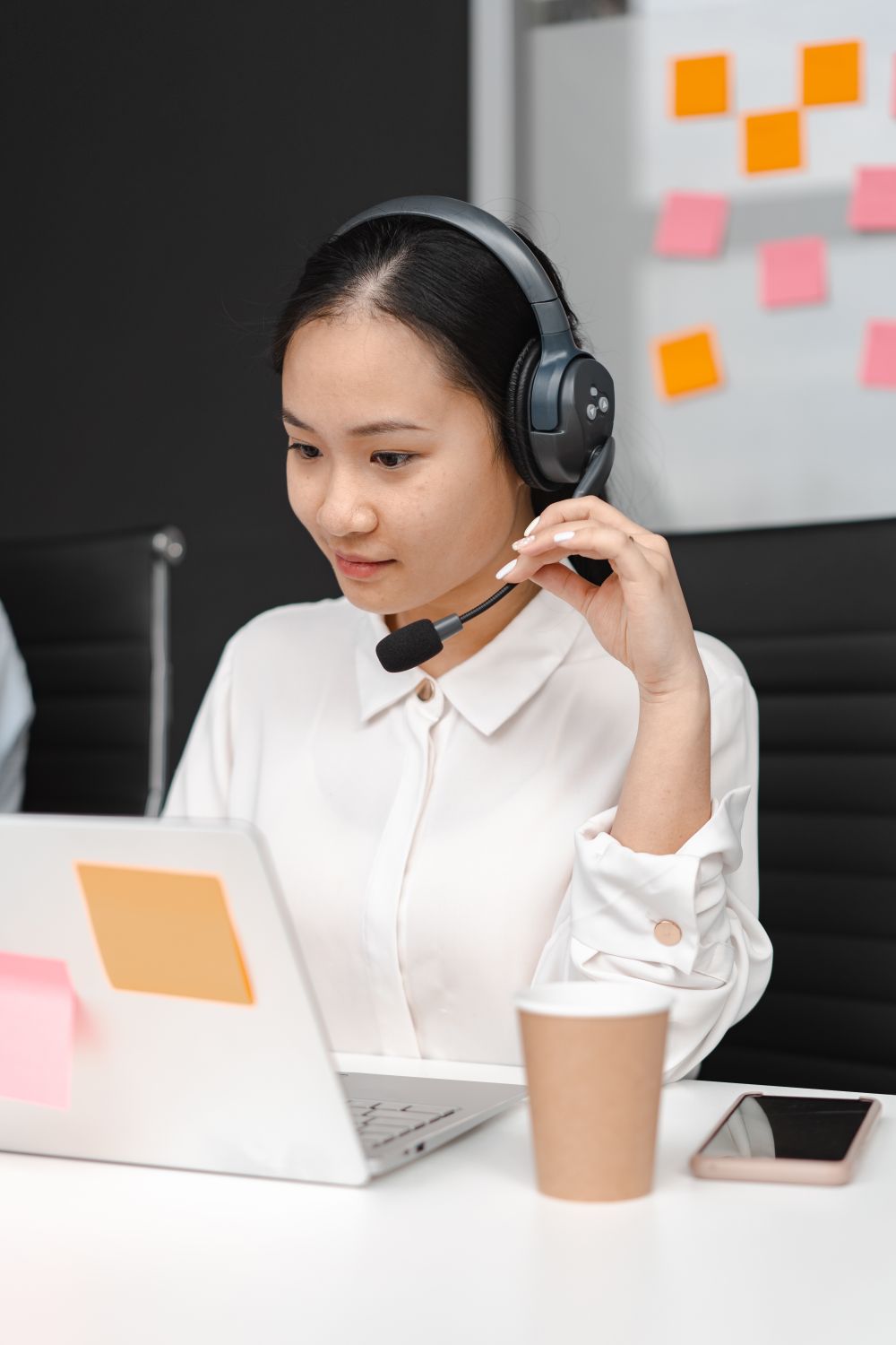 Customer representative communicating on phone and laptop